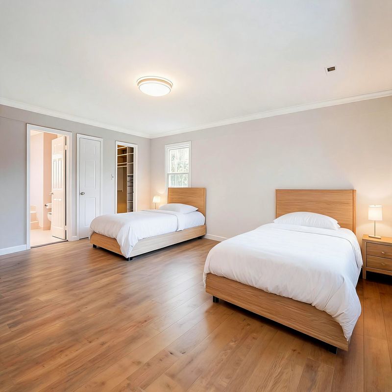 A resident bedroom as a proposed finish concept — two twin beds with light oak headboards at either end of the room, white bedding, oak flooring