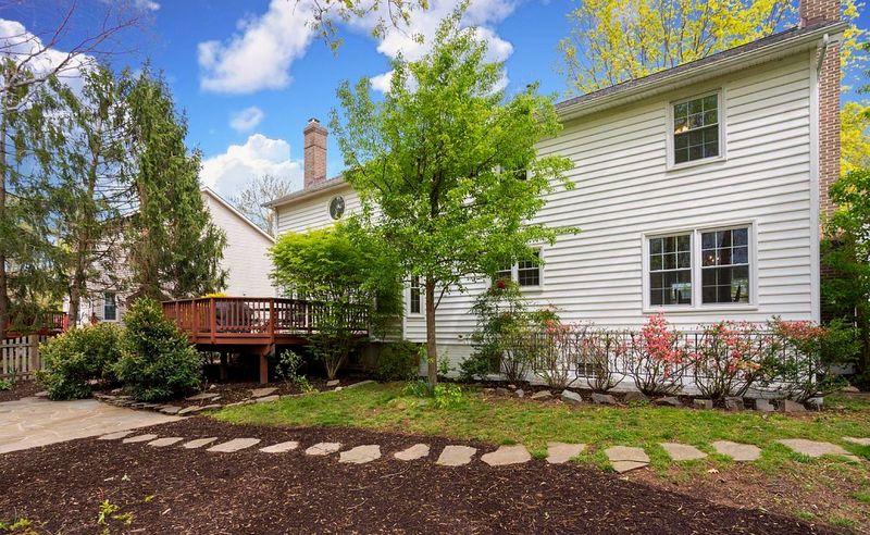 The back of the house with its raised deck, lawn and planted borders