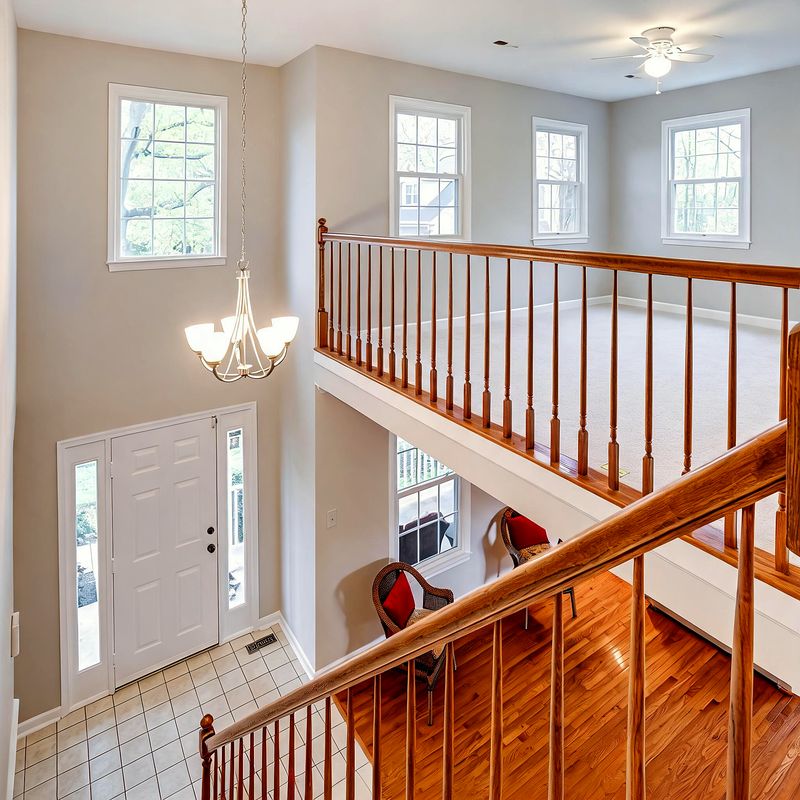 The upstairs landing with oak railings and a chandelier, overlooking the entrance hall and staircase